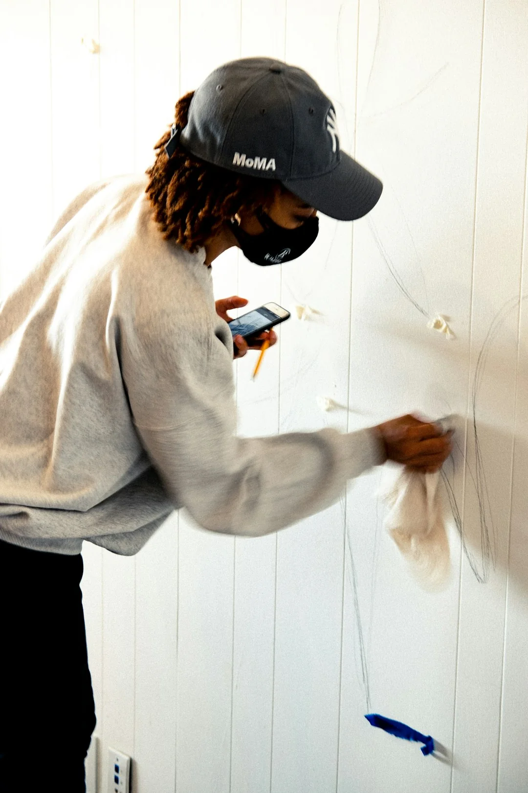 A man in coveralls cleans a large window in a stylish, modern home interior.